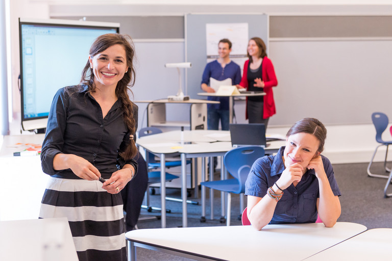 eine Dozentin steht an einem Smartboard drei weitere Personen sind anwesend