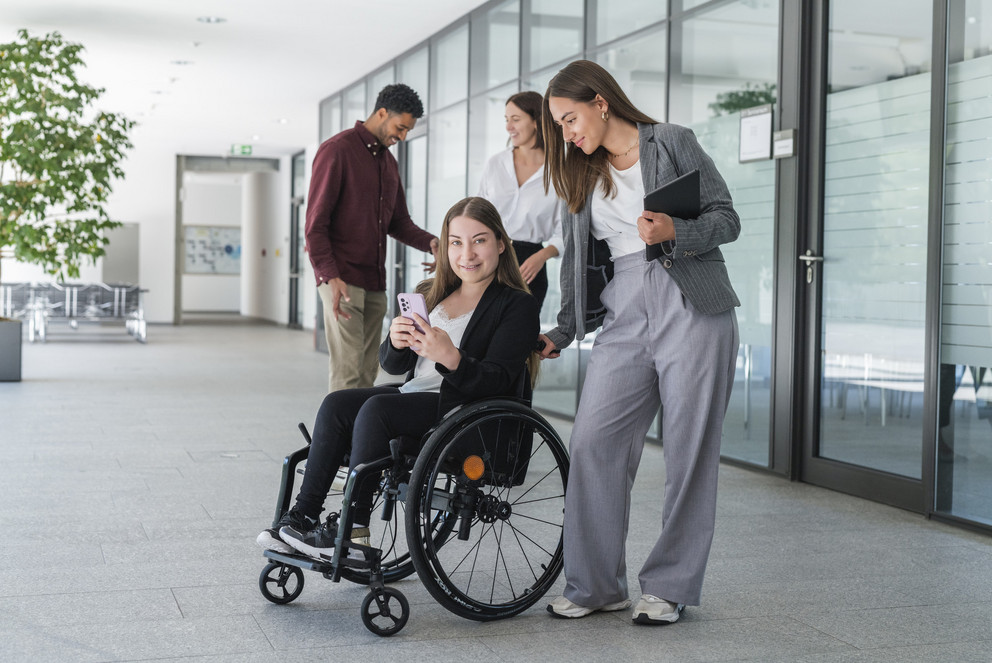 Vier Studierende, davon sitzt eine im Rollstuhl