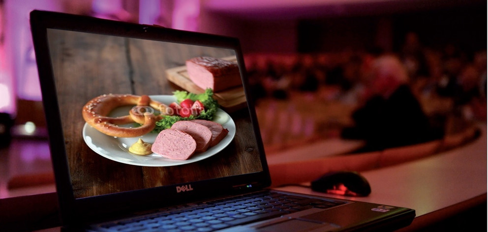 Offener Laptop mit Foto von Teller mit Leberkäse, Breze und Garnierung