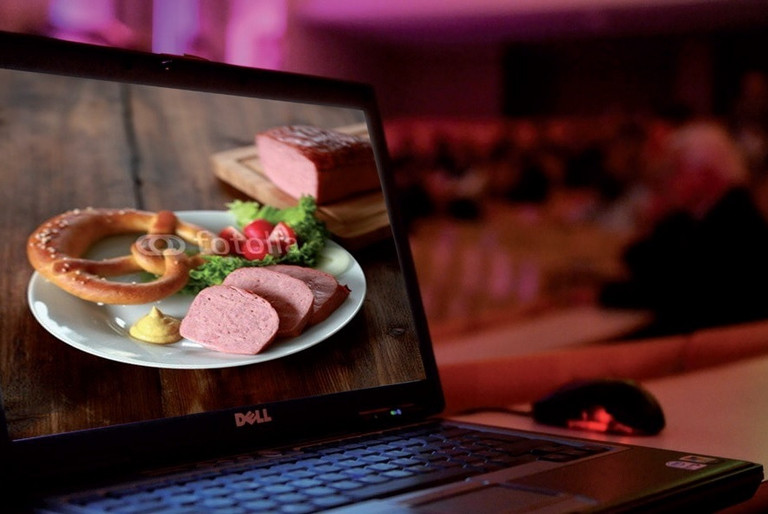 Offener Laptop mit Foto von Teller mit Leberkäse, Breze und Garnierung