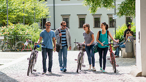 Studierende mit Fahrrädern auf dem Campus