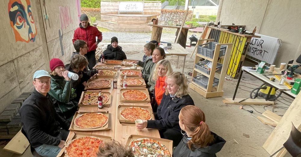 Mitglieder des Kulturtransport essen gemeinsam Pizza