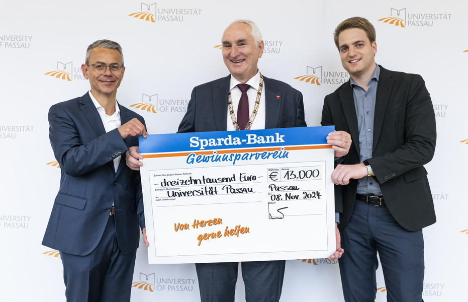 Michael Gruber, Vorstandsvorsitzender der Sparda-Bank Ostbayern eG (li), übergab gemeinsam mit Stephan Brandler, Leiter der Sparda-Bank-Filiale Passau (re) den Spendenscheck an Universitätspräsident Prof. Dr. Ulrich Bartosch (Mitte); Foto: Universität Passau