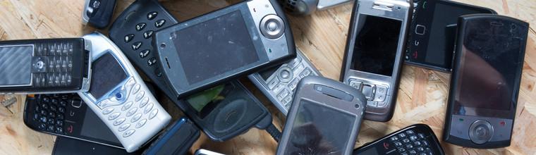 Old and obsolete cellphone on wooden background