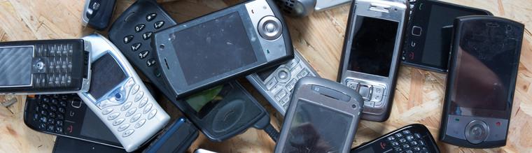 Old and obsolete cellphone on wooden background