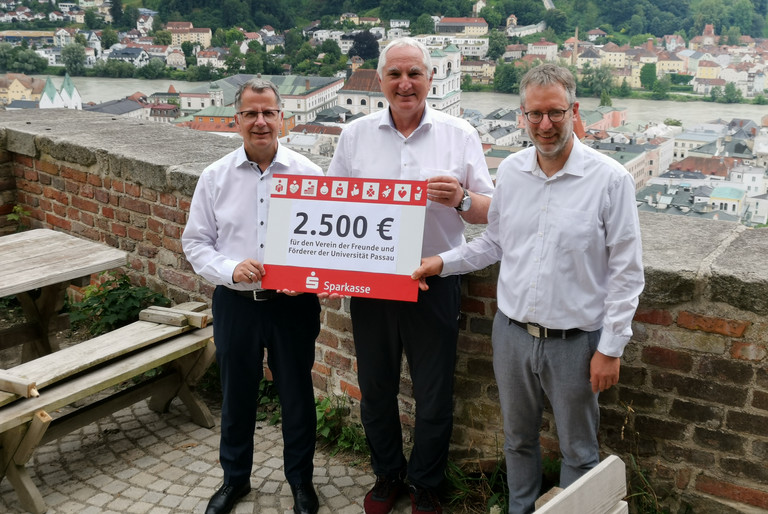 Christoph Helmschrott, Obmann des Sparkassenbezirksverbandes Niederbayern und Vorstandsvorsitzender der Sparkasse Passau (links), übergibt den Spendenscheck an Prof. Dr. Ulrich Bartosch, Präsident der Universität Passau, und Dr. Dr. Ansgar Grochtmann, Geschäftsführer des Vereins der Freunde und Förderer der Universität Passau e.V. (rechts), Foto: Universität Passau