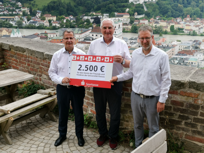 Christoph Helmschrott, Obmann des Sparkassenbezirksverbandes Niederbayern und Vorstandsvorsitzender der Sparkasse Passau (links), übergibt den Spendenscheck an Prof. Dr. Ulrich Bartosch, Präsident der Universität Passau, und Dr. Dr. Ansgar Grochtmann, Geschäftsführer des Vereins der Freunde und Förderer der Universität Passau e.V. (rechts), Foto: Universität Passau