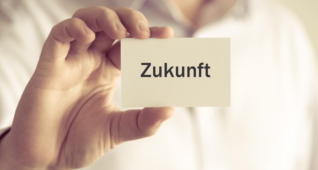 Mann zeigt Zettel mit Aufschrift Zukunft